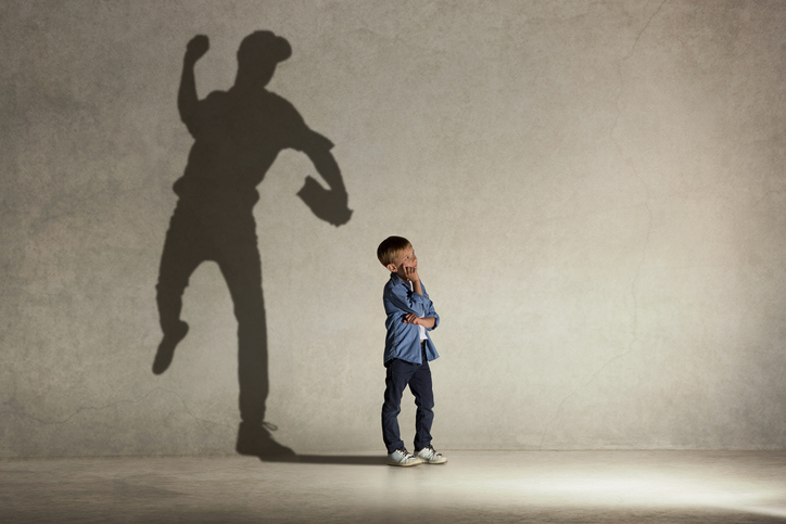 American baseball champion. Childhood and dream concept. Conceptual image with boy and shadow of fit athlete on the studio wall (American baseball champion. Childhood and dream concept. Conceptual image with boy and shadow of fit athlete on the studio